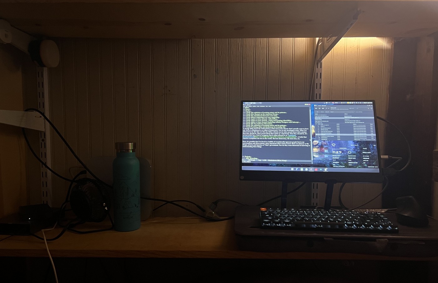 On the left my Trisquel GNU/Linux computer sit on a shelf. On the same shelf, right side a moveable lapdesk with a 15 inch mobile display in a stand with a Keychron K3 keyboard and a mouse.